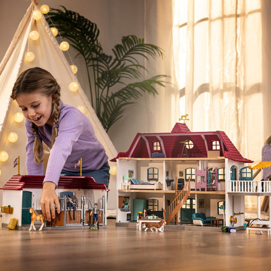 Child playing with Schleich Lakeside Country House & Stable indoor setting