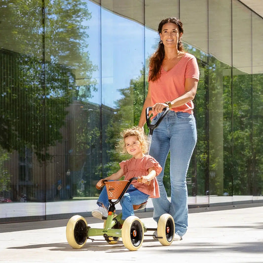 child being pushed on go-kart