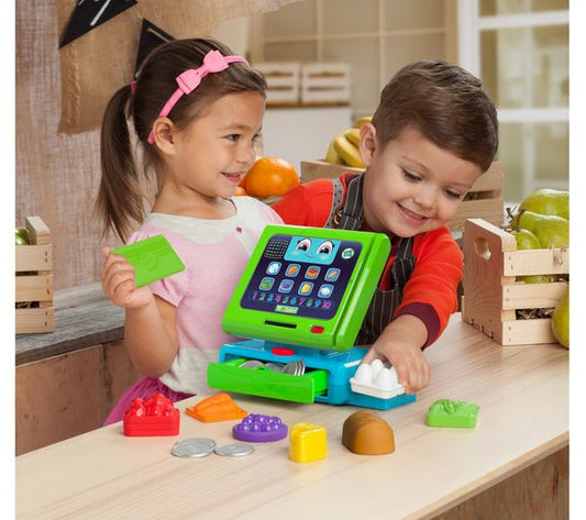 two toddlers playing with toy till in play kitchen