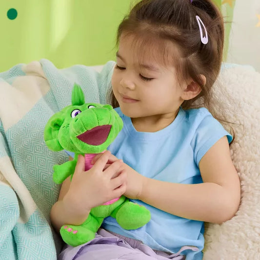 young girl holding bright green and pink plush dinosaur on sofa