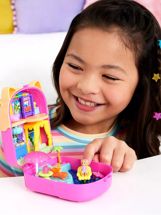 young girl playing with brightly coloured kitty compact and smiling