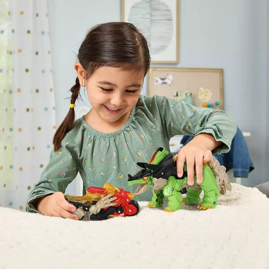 Young girl playing with green dinosaur and red motorbike on sofa