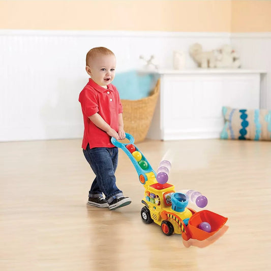 toddler playing with toy digger and smiling
