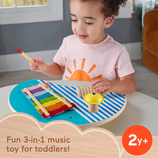 toddler playing with wooden music table