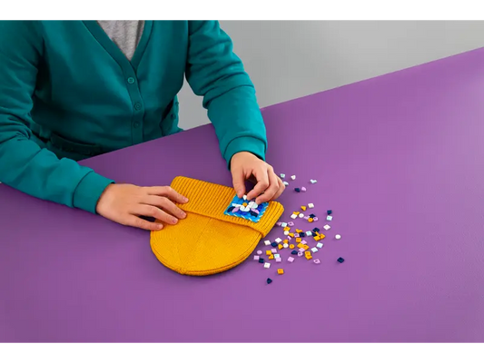 A child decorating a fabric patch with LEGO 41955 Stitch-on Patch tiles.