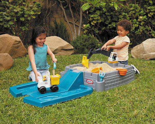 Child playing with the working excavator in the sandbox