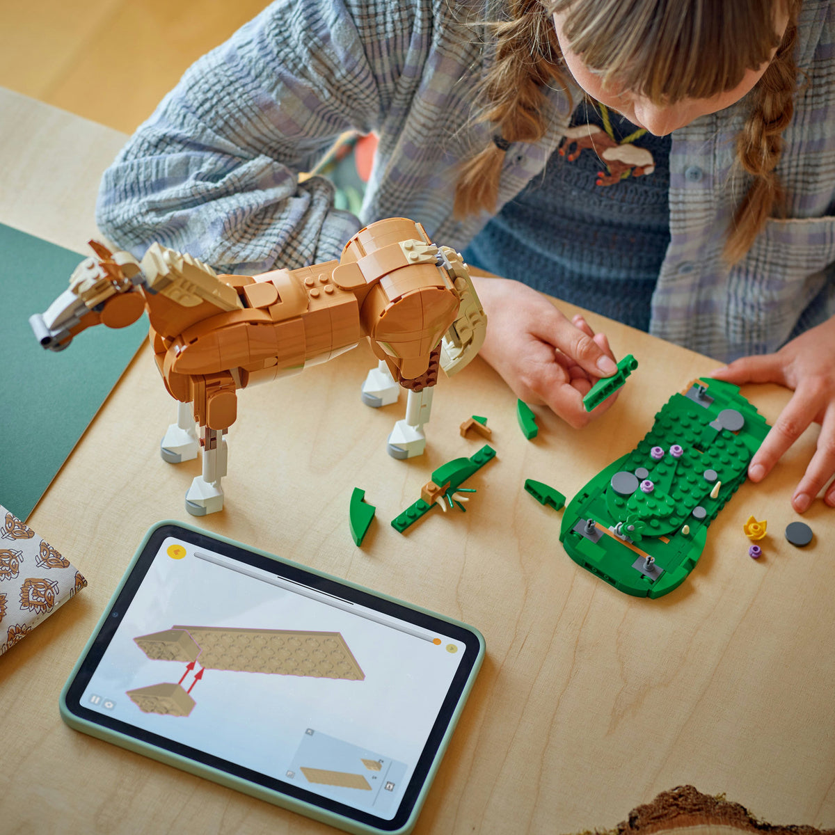 birds eye view of young girl building LEGO horse set 