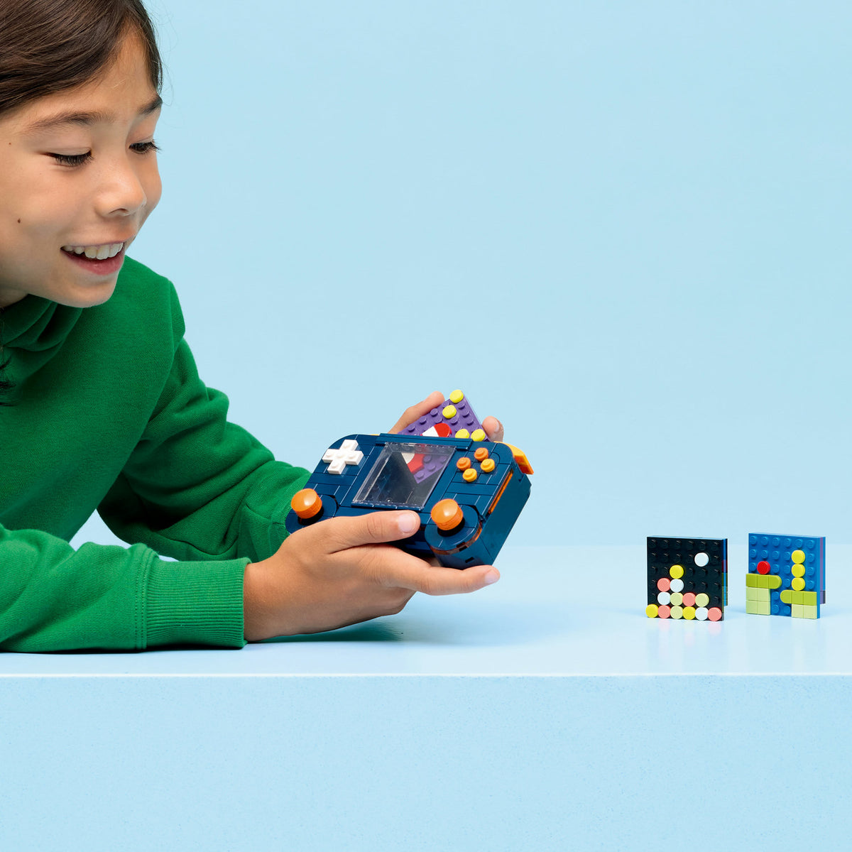 boy playing with 3-in-1 retro gaming lego consoles 