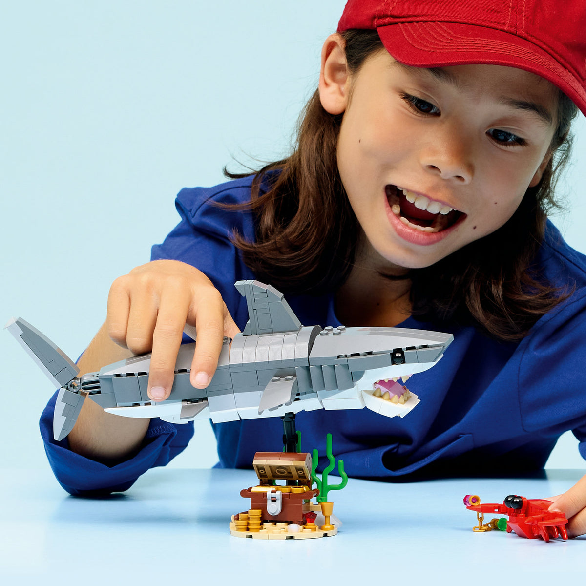girl playing with lego creator shark with treasure chest 
