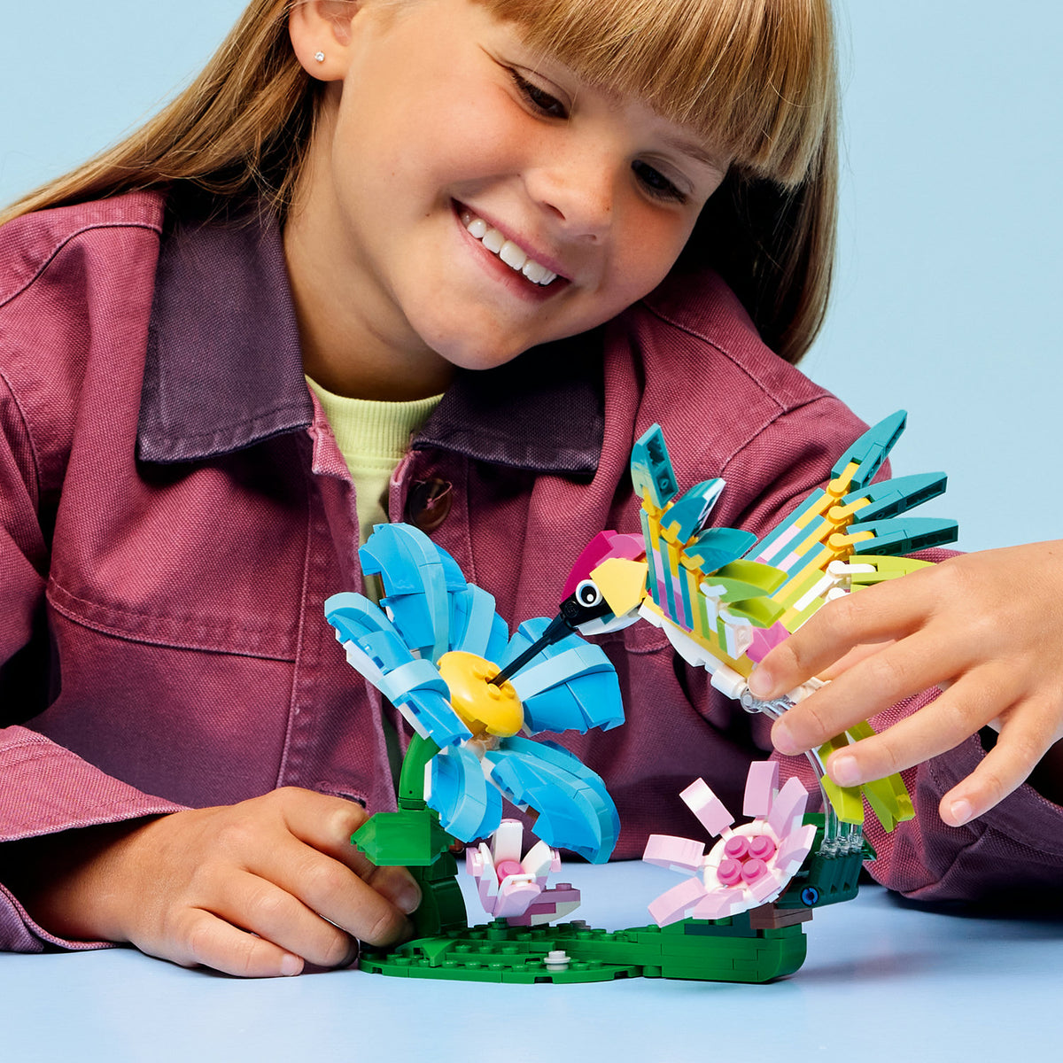 girl playing with hummingbird lego set 