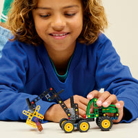 child playing with john deere wheeled harvester 