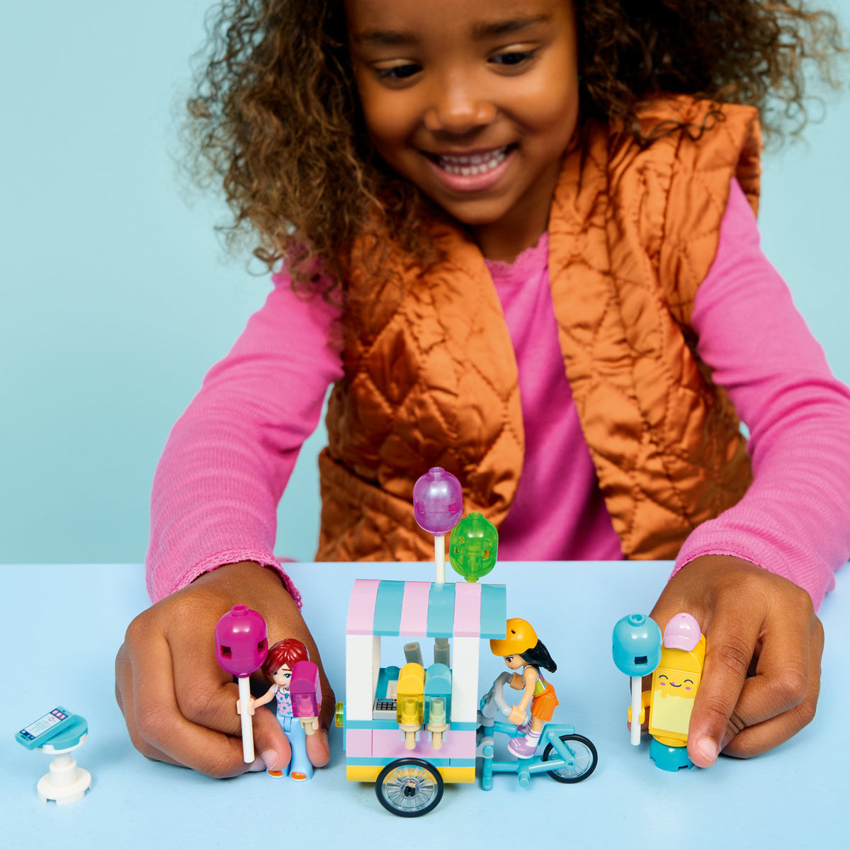 girl playing with lego ice cream and balloon stand 