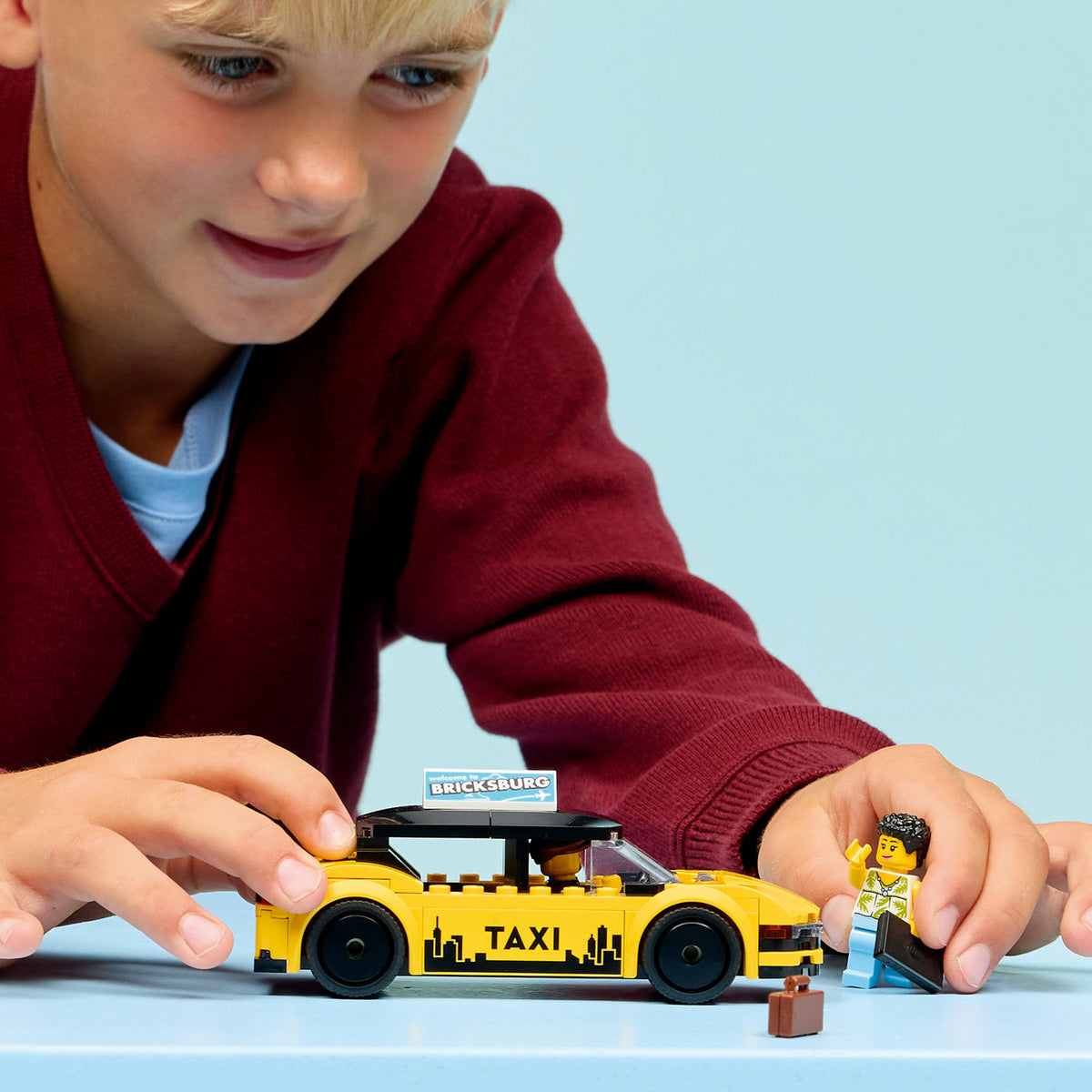 boy playing with lego city yellow taxi 