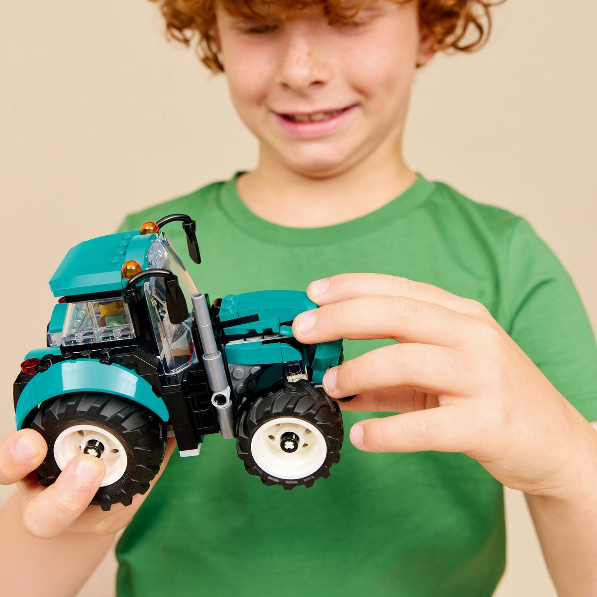 boy holding lego tractor 
