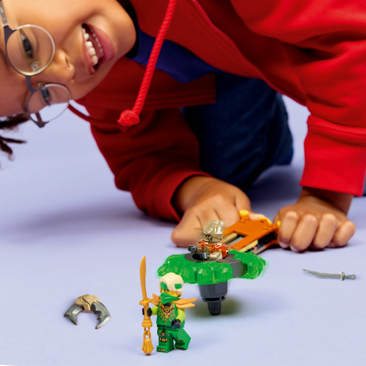 boy playing with lego lloyd vs earth monster spinner