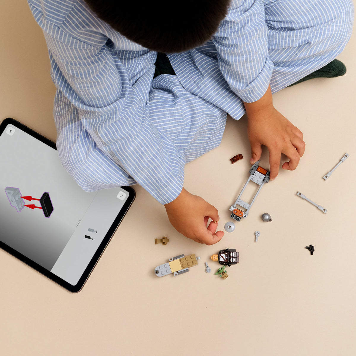 boy building lego star wars the mandalorian and grogus speeder bike 