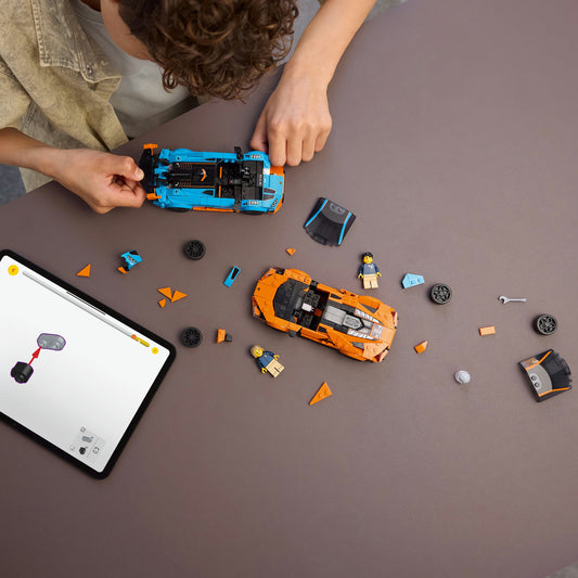 birds eye view of a young boy building two LEGO cars 