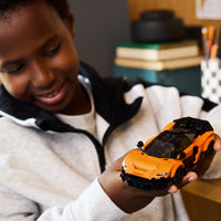 boy holding orange lego car 