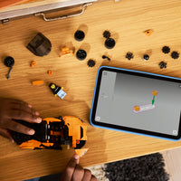 hands building orange lego car 