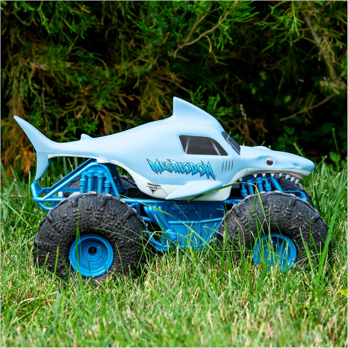 Toy shark vehicle with monster truck wheels on grass
