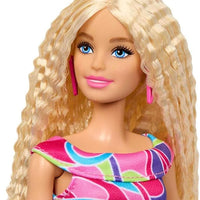 Celebrate Barbie’s iconic 65th anniversary with Doll #223, featuring a blonde wavy hairstyle and fashionable Totally Hair-inspired attire.
