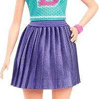 Barbie Fashionistas Doll #232 with red hair, wearing a sporty "B" jersey top, pleated purple skirt, and sneakers.
