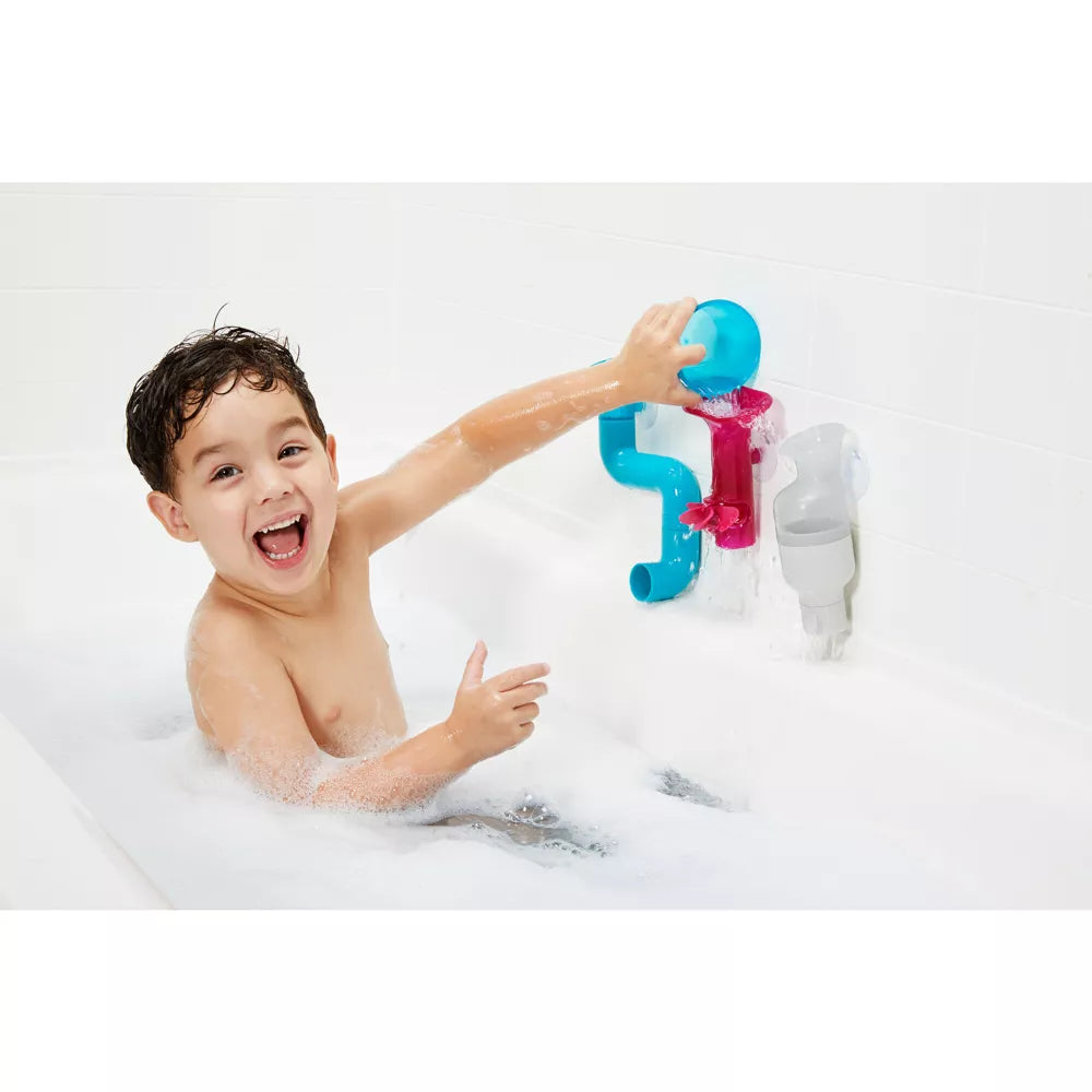 child playing with bath toy pipes 
