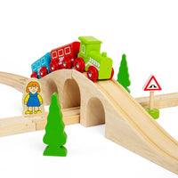 close up of green wooden train going over arch of wooden track 