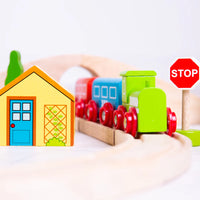close up wooden train, wooden stop sign and yellow wooden house 