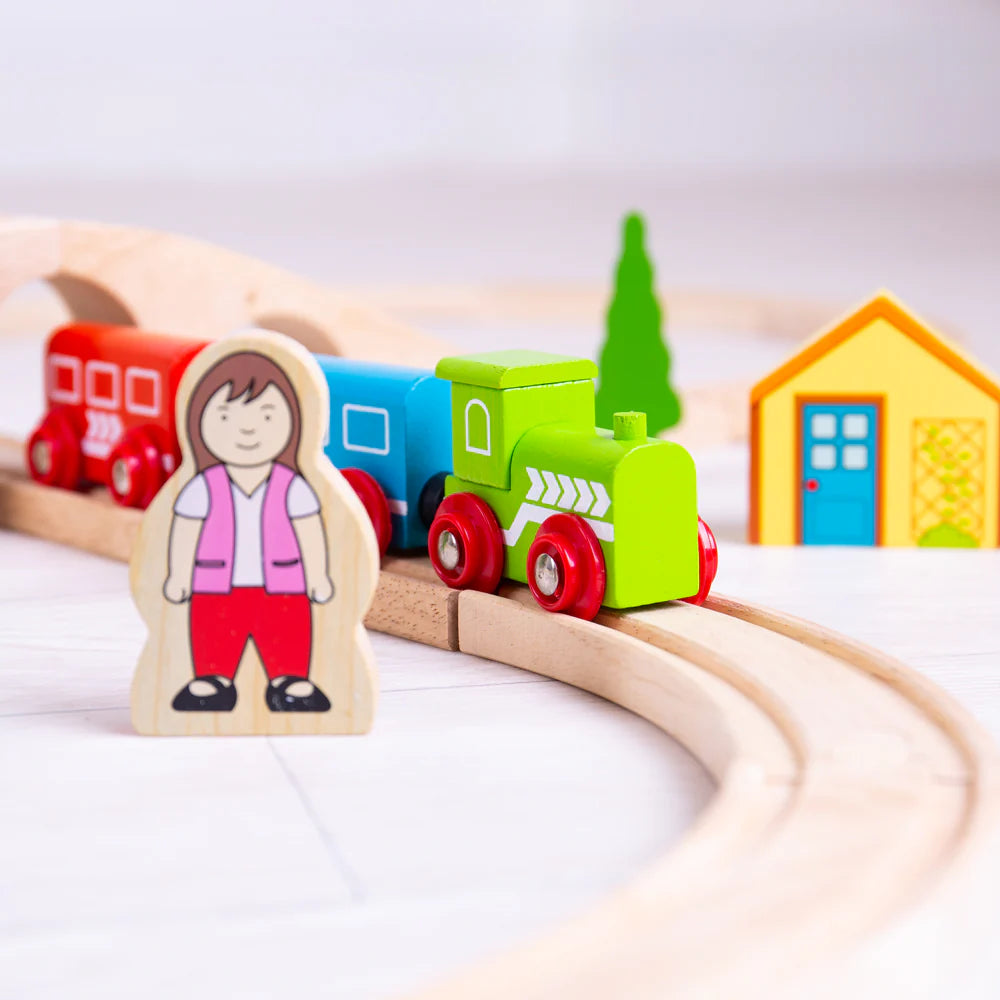 close up of wooden female characeter and green wooden train 