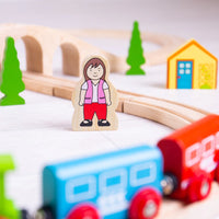 close up of wooden female character surrounded by wooden train and pieces 