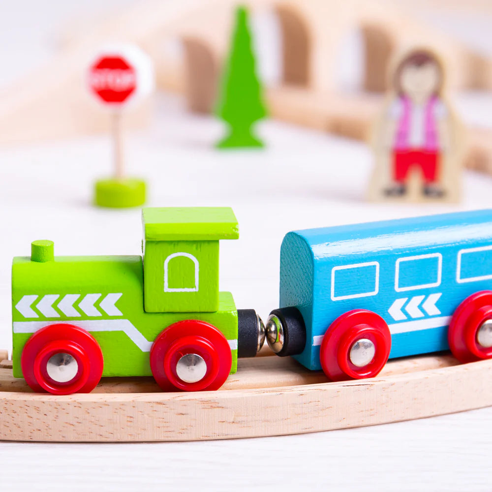 close up of green wooden train and attachment on wooden track 