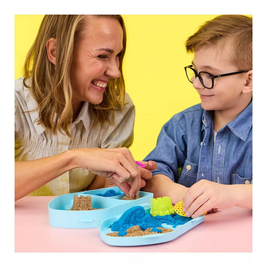 mother and son playing with kinetic sand at a table.