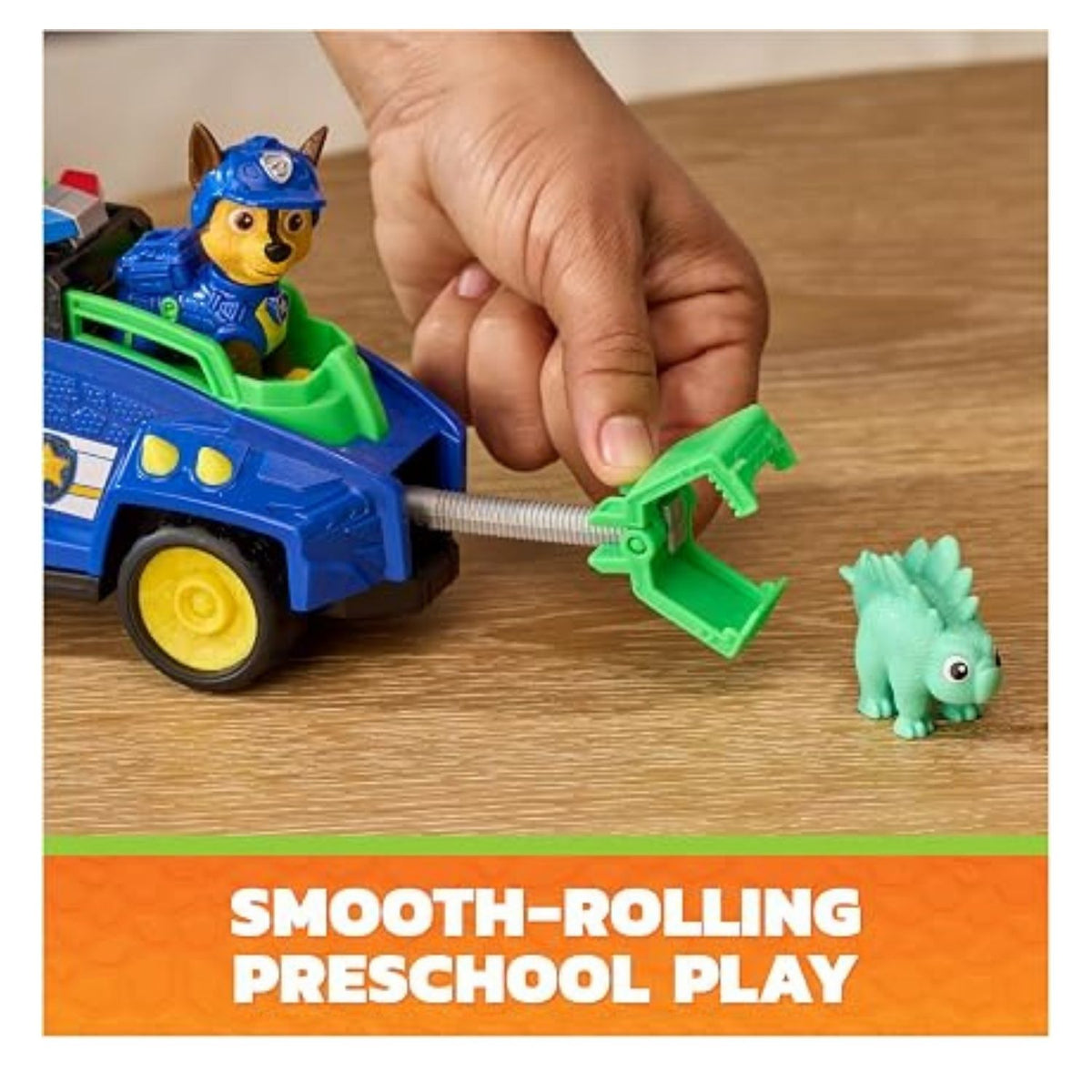PAW patrol vehicle figurine on wooden table as someone plays with it 