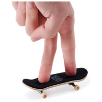 a hand showcasing how to use the finger skateboard against a white background.