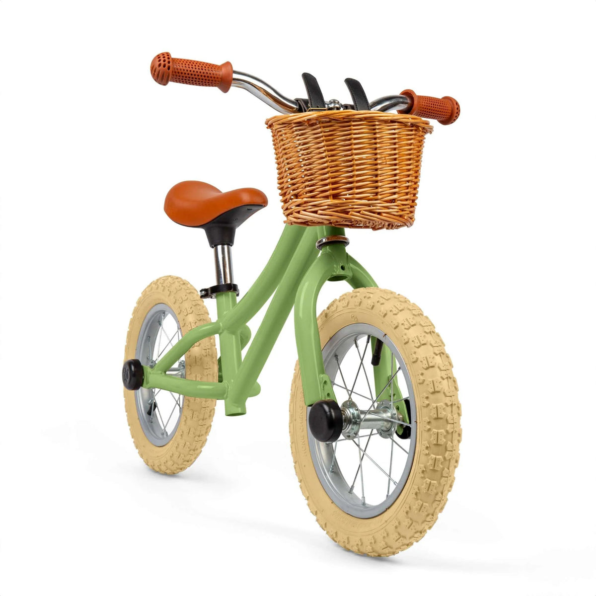 Green balance bike with brown basket, seat and handles on white background