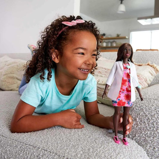 girl playing with barbie doctor doll 