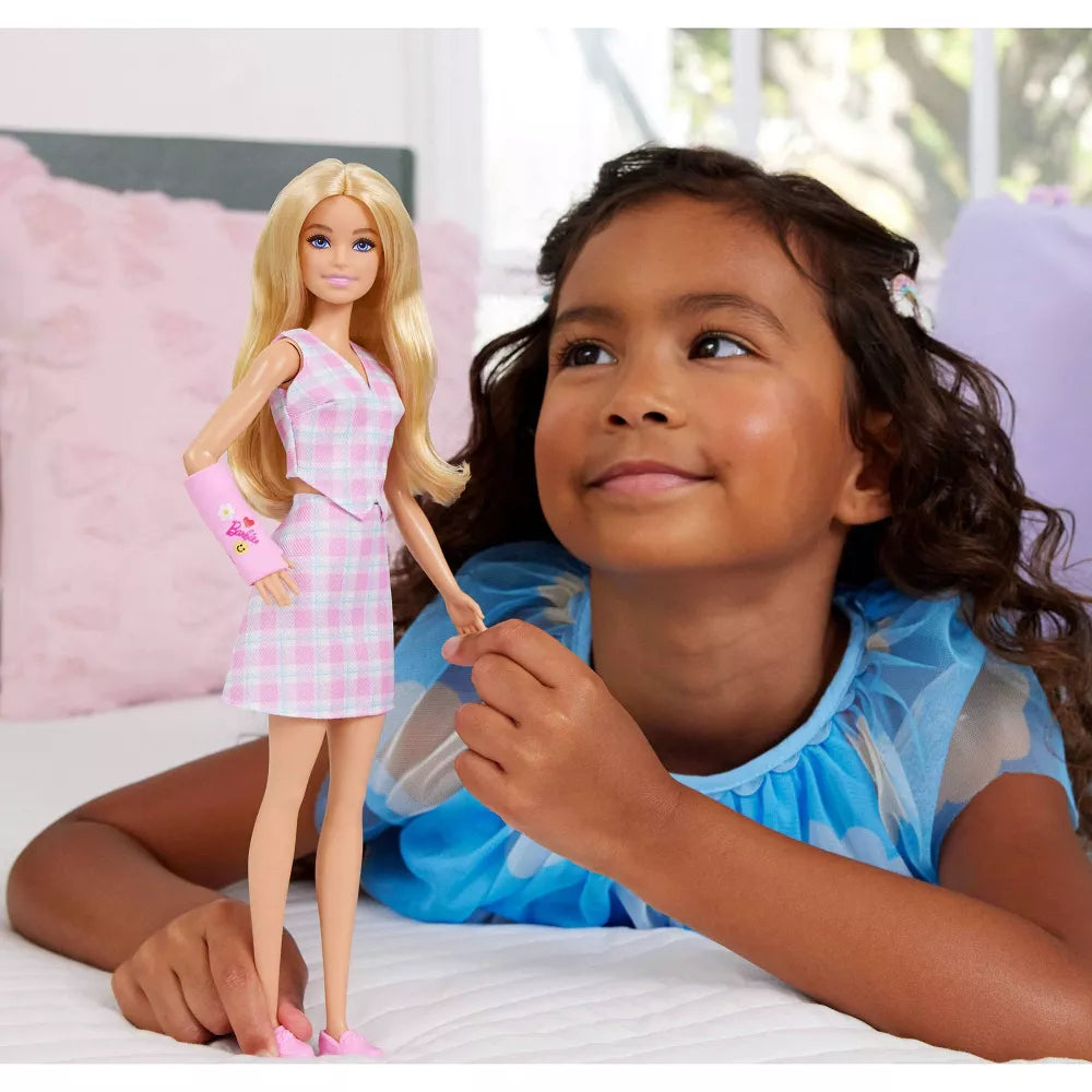 girl playing with barbie doll with cast 