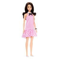 black haired barbie with pink gingham dress on white background 