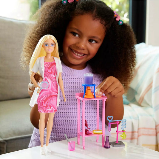 young girl playing with scientist doll and accessories 