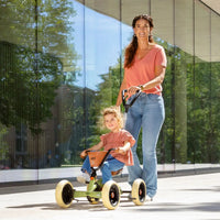 child being pushed on go-kart