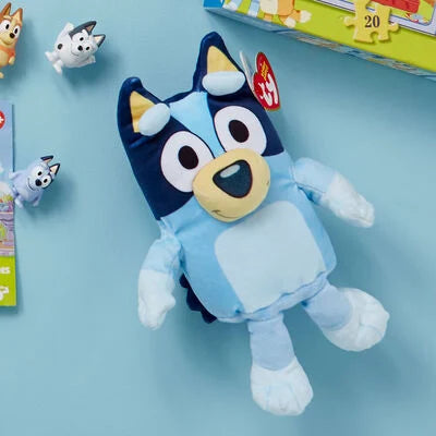 bluey plush lying on blue background
