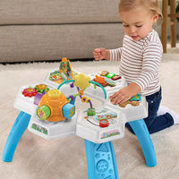 toddler playing with brightly coloured activity table 