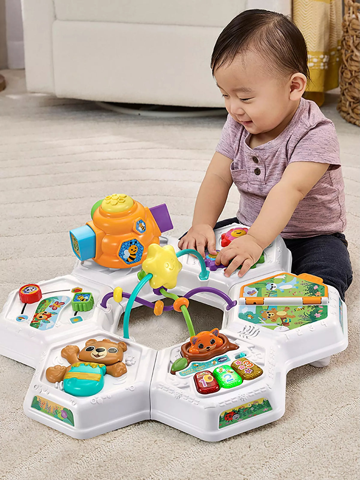 baby playing with top of activity table 