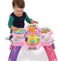 toddler playing with bright pink activity table on white background 