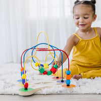 toddler playing with wooden maze toy 