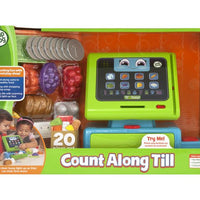 green and blue toy till in packaging on white background 