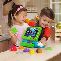two toddlers playing with toy till in play kitchen 