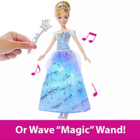 hand waving wand over doll in blue dress to make music start 