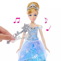 hand waving wand over doll in blue dress as music plays 